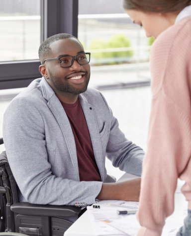 adult man sitting on the wheelchair looking at adult woman